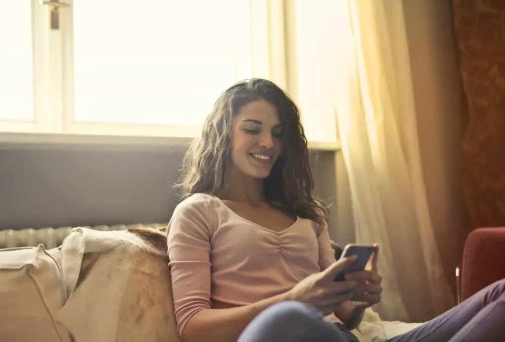 woman-smiling-at-phone-dating-app